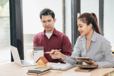 Emlakçı ev satın alma sözleşmesi imzalamayı açıklıyor. Banka müdürü ev satın alma sözleşmesi imzalamayı açıklıyor. Banka müdürü ve emlak konsepti.