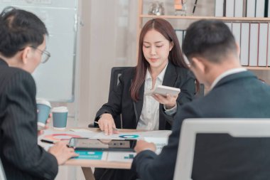 İş adamları yatırım ve iş büyümesi hakkında grafikler ve grafikler üzerinde tartışıyorlar. Ofisteki mali verileri analiz eden iş arkadaşları.