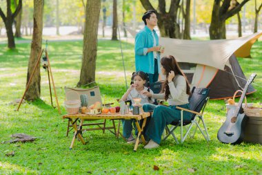 Ormanda seyahat eden ve kamp yapan Asyalı aile aile aile, aile zamanı, macera ve seyahat konsepti aile aktiviteleri ve açık hava aktiviteleri sırasında mutlu hisseder.