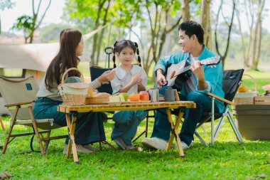 Ormanda seyahat eden ve kamp yapan Asyalı aile aile aile, aile zamanı, macera ve seyahat konsepti aile aktiviteleri ve açık hava aktiviteleri sırasında mutlu hisseder.