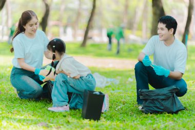 Yaz tatilinde Asyalı aile, çocuklara plastik şişe ve çöp toplamayı öğreten ebeveynler, çevreyi korumak için gönüllü konsept..