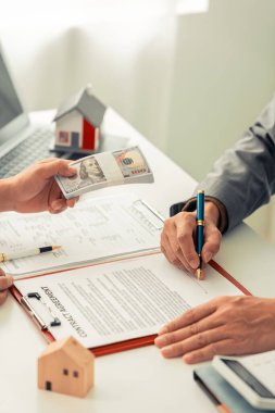 Emlakçı ev satın alma sözleşmesinin şartlarını görüştü ve müvekkilden sözleşmeyi yasal olarak tamamlamak için belgeyi imzalamasını istedi..