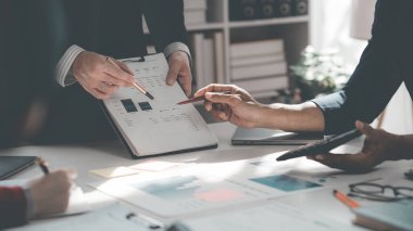 İş adamları tartışıyor, masada finansal tablolar ve grafikler var, başarılı takım çalışmalarının sonuçlarını gösteren grafikler ve grafikler hakkında tartışıyorlar..