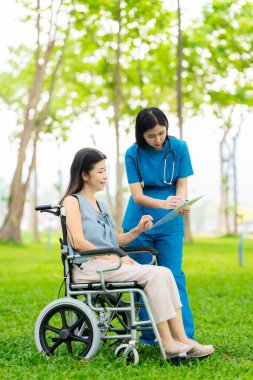 Bakıcı yaşlıları sağlık terapisi için parka götürüyor. Yaşlılar için sigorta konsepti, mutlu emeklilik.