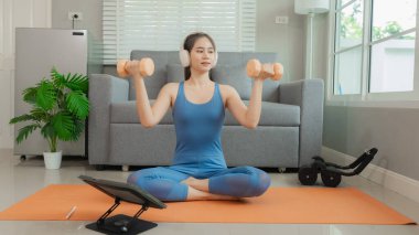 Mutlu Asyalı kadın evde yoga yapıyor ve omuzlarını esnetiyor. Yoga. Paspasın üzerinde geriniyor. Sağlıklı egzersiz. Sağlıklı yaşam tarzı.