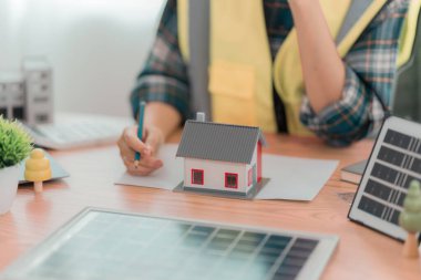 Ofisteki masada güneş paneli planları üzerinde çalışan mühendis ya da mimar. İnşaat konsepti.