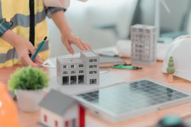 Ofisteki masada güneş paneli planları üzerinde çalışan mühendis ya da mimar. İnşaat konsepti.