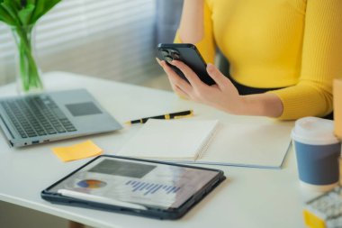 KOBİ tedarik zinciri kavramı, satın alma, Asyalı kadın girişimci dizüstü bilgisayar üzerinde çalışırken not alıyor, müşteri küçük işletme mağazalarında siparişleri yönetiyor.