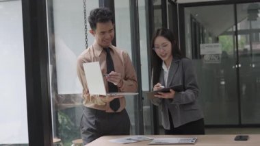 Asyalı iş kadını, konferans odasında boş beyaz tablet üzerinde bilgisayar kullanarak, konuşarak, tartışarak ve iş problemlerini çözerek belgeyi açıklıyor.