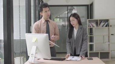 Asyalı iş kadını, konferans odasında boş beyaz tablet üzerinde bilgisayar kullanarak, konuşarak, tartışarak ve iş problemlerini çözerek belgeyi açıklıyor.