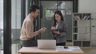 Asyalı iş kadını, konferans odasında boş beyaz tablet üzerinde bilgisayar kullanarak, konuşarak, tartışarak ve iş problemlerini çözerek belgeyi açıklıyor.