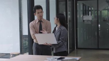 Asyalı iş kadını, konferans odasında boş beyaz tablet üzerinde bilgisayar kullanarak, konuşarak, tartışarak ve iş problemlerini çözerek belgeyi açıklıyor.