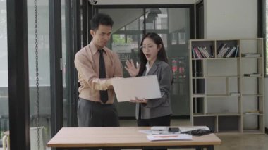 Asyalı iş kadını, konferans odasında boş beyaz tablet üzerinde bilgisayar kullanarak, konuşarak, tartışarak ve iş problemlerini çözerek belgeyi açıklıyor.