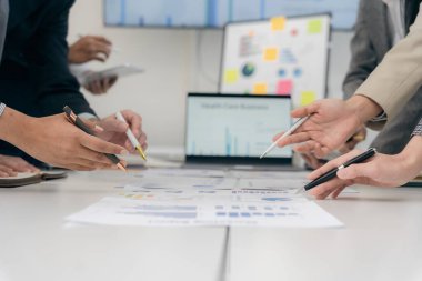 İş adamları başarılı takım çalışmalarının sonuçlarını, borsa grafiklerini ve ofisteki tabletleri işaret eden grafikleri tartışıyor..