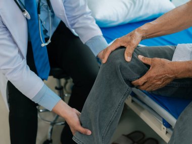 Bir ortopedik cerrahi kliniğindeki yaşlı hastalarda fizyoterapistler muayene, masaj ve diz ve bacak yaralanmalarını tedavi ederler. İlgili doktor ya da hemşire