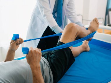 Bir ortopedik cerrahi kliniğindeki yaşlı hastalarda fizyoterapistler muayene, masaj ve diz ve bacak yaralanmalarını tedavi ederler. İlgili doktor ya da hemşire