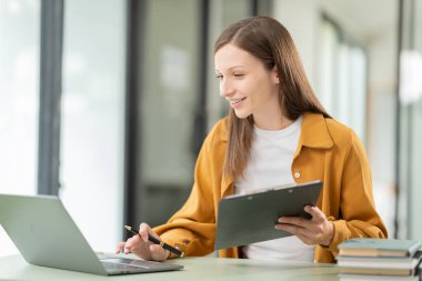 Eğitim, teknoloji, internet ve insanlar kavramı - Dizüstü bilgisayarlı gülümseyen genç kadın kahve dükkanında oturuyor ve çalışıyor. Teknoloji konsepti.