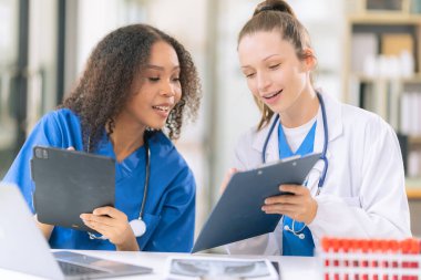 Bilim konsepti. İki kadın doktor modern bir tıp laboratuarında mikroskop altında maddeler üzerinde araştırma yapıyorlar..