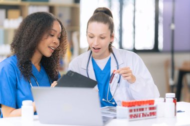 Bilim konsepti. İki kadın doktor modern bir tıp laboratuarında mikroskop altında maddeler üzerinde araştırma yapıyorlar..