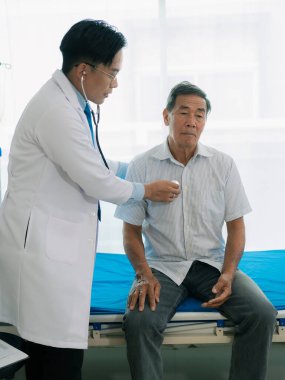 Bir hastanın kalp atışlarını dinlemek için steteskopla hastayı muayene eden bir doktorun görüntüsü tedavi ve önleyici bakım için bir kılavuz olarak. Kalp hastalığı sağlık taraması kavramı.