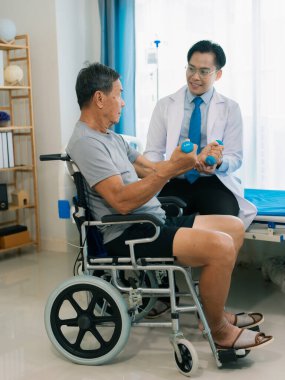 Asyalı fizyoterapist ve tekerlekli sandalyedeki yaşlı hasta halter kemeri tutuyor. Dambılı sağlık hizmeti. Yaşlı insanlar yaşlanıyor. Uyumlu spor aktiviteleri.