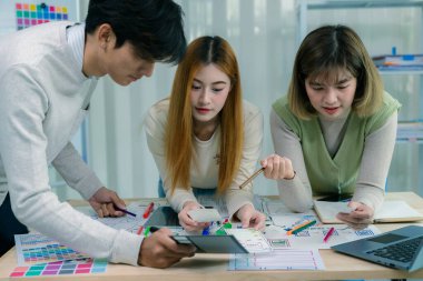 Bir geliştirici ekibi, kullanıcı akışı çizimleri ve tasarım araçları ile çevrili web sitesi ve mobil uygulama prototipleri için kablo çerçeveleri üzerinde çalışarak UXUI tasarımları planlamak için işbirliği yapar..