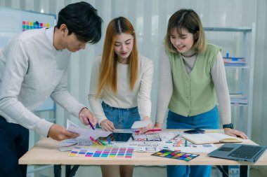 Bir geliştirici ekibi, kullanıcı akışı çizimleri ve tasarım araçları ile çevrili web sitesi ve mobil uygulama prototipleri için kablo çerçeveleri üzerinde çalışarak UXUI tasarımları planlamak için işbirliği yapar..