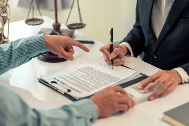 İş müşterisi ve ahşap tokmak ile ilgili önemli davalarda sözleşmeli belgelerle çalışan erkek avukat, mahkeme salonunda pirinç pullar. Adalet ve hukuk. Kapat..