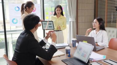 İş ortakları bir toplantıda belge ve fikirleri tartışıyor ve iş adamları ve kadınlar birlikte çalışırken mutlu bir şekilde gülümsüyorlar. 4k ağır çekim videosu.