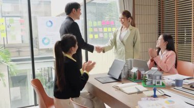 Emlak işadamı müşteriyle tokalaşıyor, satış kapanıyor, danışmanlık yapıyor ve masa başında konuşuyor, imzalamadan önce sözleşmeyi tartışıyor, el sıkışıyor, yavaş çekim videosu çekiyor..