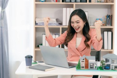 Heyecanlı Asyalı genç emlakçı evini yatırım için satıyor ve iş ve finans sunumları sunuyor..