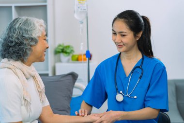 Doctor is examining elderly female patient in ward while doctor is checking her condition in recovery room. Medical and healthcare concept.
