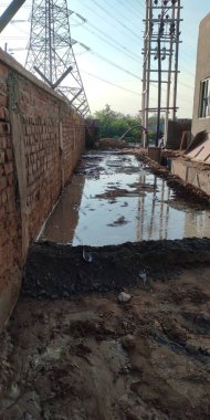 İnşaat tarafındaki duvarın yanında küçük çamurlu bir gölet.