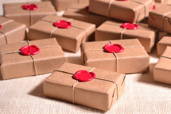 Wedding details favor brown craft guest gift boxes with custom red wax seal stamp, rustic fall autumn style weddings party, original handmade presents ideas, ecological concept, natural soaps