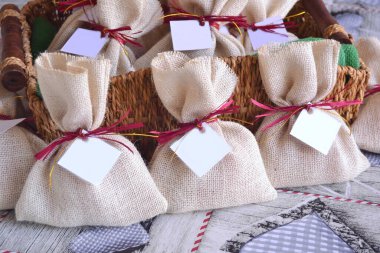 Noel hediyeleri, jüt çantalar kokulu keseler kırmızı altın kurdele, sahte kış düğün hediyeleri, küçük hediyeler kırsal tarz parti, hasır arka plan.