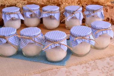 Baby shower baptism favors candles blue white color jute ribbon wood and flowers background, first communion gifts, birthday souvenirs or wedding favours vintage retro style, handmade presents clipart