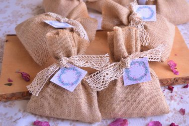 Düğün, jüt çantalarından, Noel hediyesinden, pamuk dantelli ahşap arka plandan, taklit taklit uzay etiketinden, diy el yapımı parti hediyelerinden, bej kahverengi renkli Souwenirs ambalajlarından, kokulu keselerden yana.