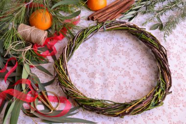 Noel çelengi el yapımı yeni yıl dekorasyon atölyesi çam ağacı brunch 'ı, okaliptüs, zeytin yaprağı, tarçın portakalı makas, kırmızı yay, jüt kış tatili aktivitesi