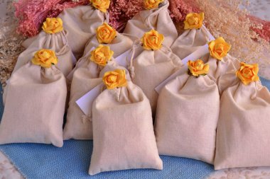 Düğün için pamuk hediye paketleri sarı çiçek süslemeleri, mavi renk jüt arka plan, misafir için parti hatıraları, kokulu el yapımı hediyeler bahar yaz tarzı.