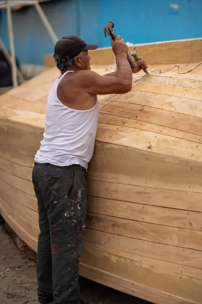 stock image Lima - Peru, May 21, 2023 - Fishermen in Lima's port are engaged in the meticulous task of mending nets and preparing boats