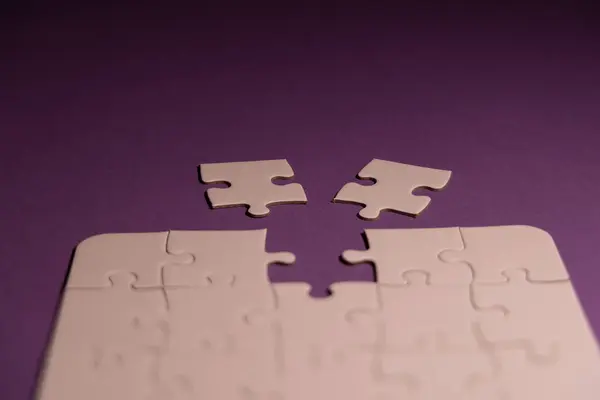 stock image A white puzzle with one missing piece and two options to choose from, symbolizing decision-making and choices in a conceptual way