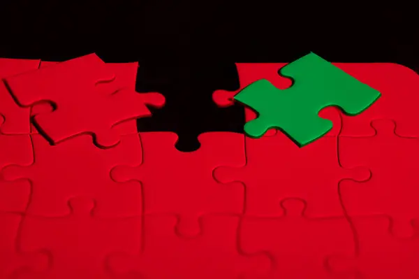 stock image Red puzzle with a green piece to choose which one fits in the hole