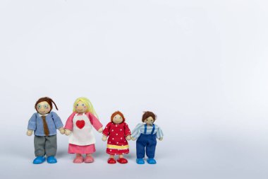 Tahta oyuncak figürleri bir aileyi betimliyor, el ele, temiz beyaz bir arka planda. Bu sahne aile içinde birlik, sevgi ve ahengi temsil eder.