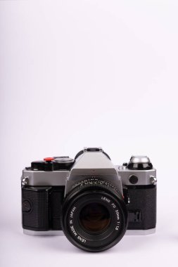 Merkezde beyaz bir arka plana yerleştirilmiş antika bir kamera..