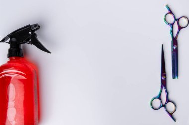 Resmin sağ ve sol köşelerine yerleştirilmiş bir makas ve tarağın yukarıdan aşağıya detaylı bir görüntüsü. Her iki unsur da berberlikteki kullanımlarını gösteren beyaz bir arka planda sergileniyor.