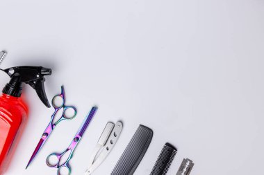 Beyaz bir arka planda ayarlanmış berber aletleri manzarası. Bakış açısı ve kırmızı renkli araçlara odaklanarak, bunların profesyonel tasarım ve işlevlerini vurguluyor