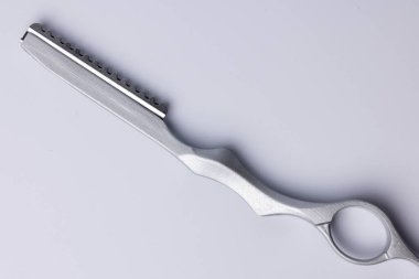 Beyaz arka planda ayrıntılı berberlerin ustura kullanışının üstten görünüşü. Tıraş bıçağı merkezde, parlak dizaynını ve keskin bıçağını vurguluyor, tıraş ve tıraş için ideal.