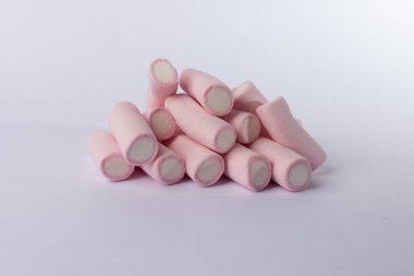 Yumuşak bir marşmelov yığını beyaz bir zemin üzerine kuruludur. Fotoğraf yatay olarak hizalanmıştır. Basitliği ve ışığı vurgular. Yumuşak şekerlemeler.