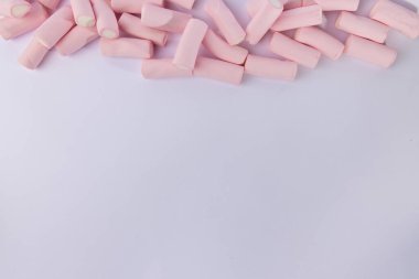 Fotoğrafın üst kısmını dolduran kaotik bir marşmelov yığınının yukarıdan aşağı görüntüsü. Görüntü yatay, marşmelovlar temiz beyaz arka plana karşı düzensiz.