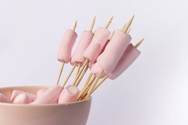 horizontal shot of a bowl filled with fluffy marshmallows and skewers with marshmallows, positioned on the left side, set against a clean white background clipart